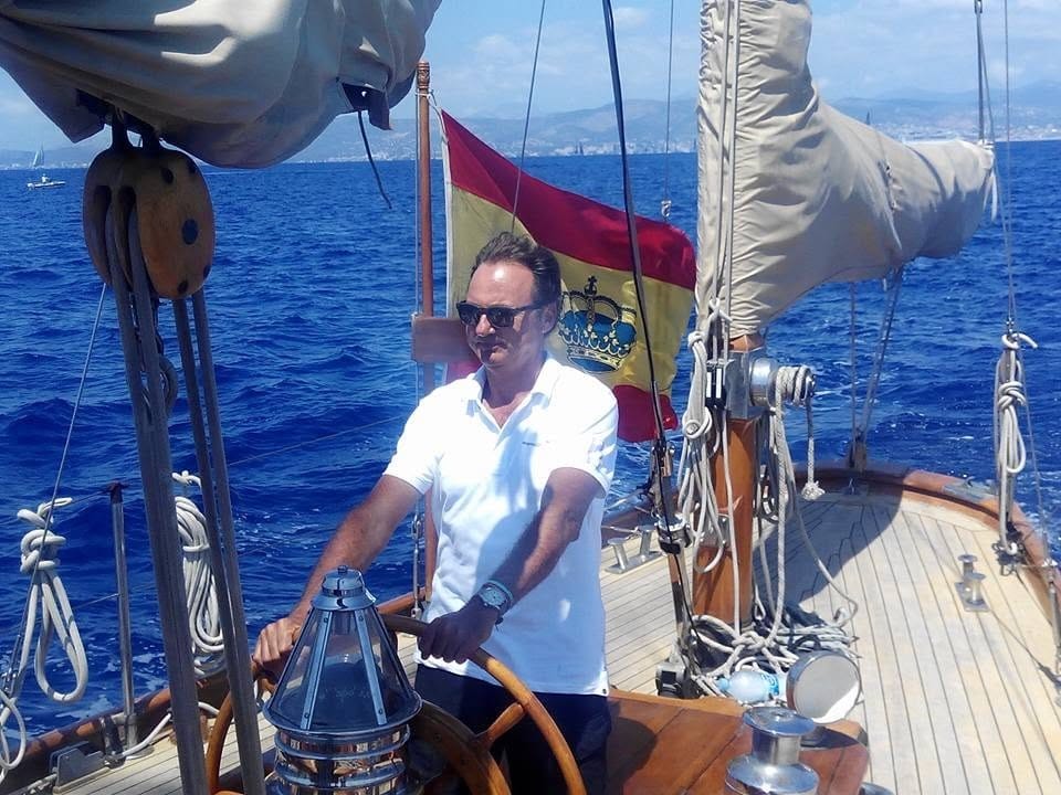 Nacho Lamadrid yacht captain at the helm of a sailing yacht