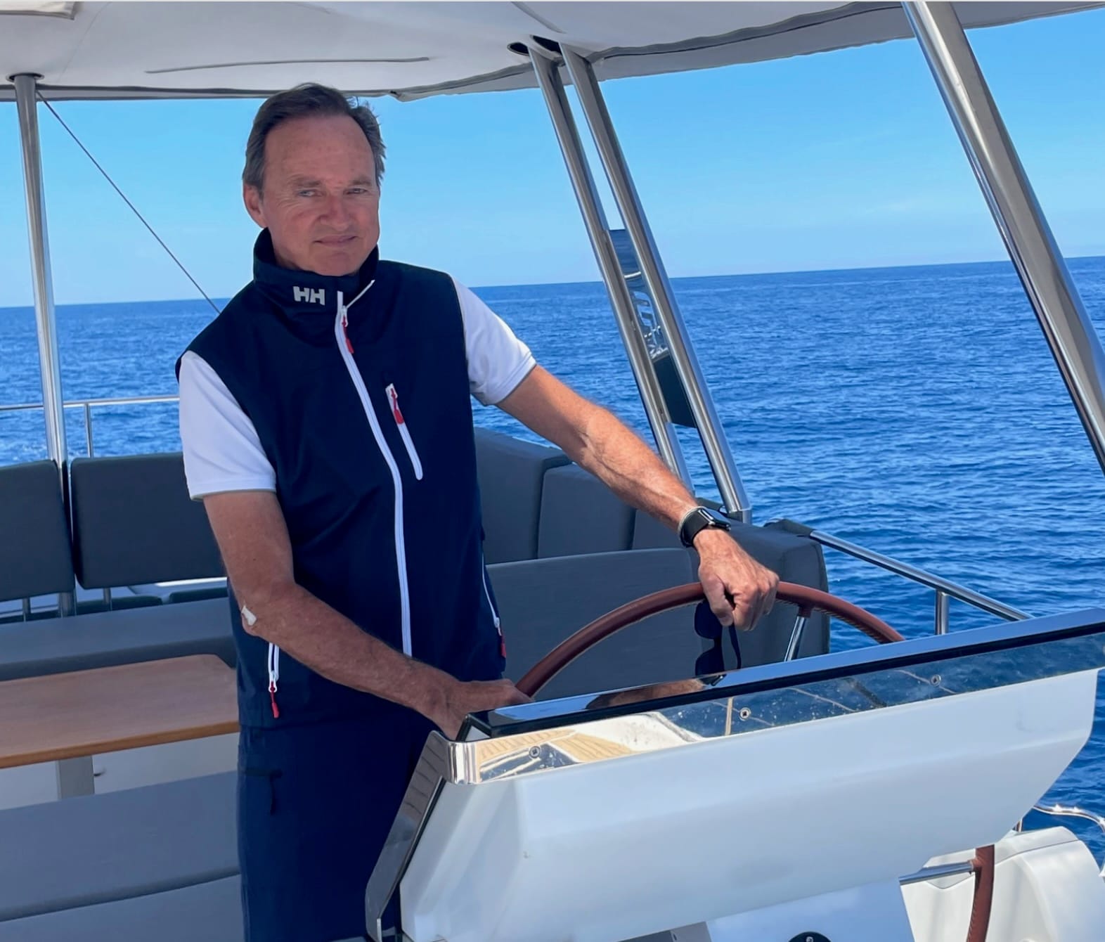 Nacho Lamadrid yacht captain at the helm of a yacht at sea